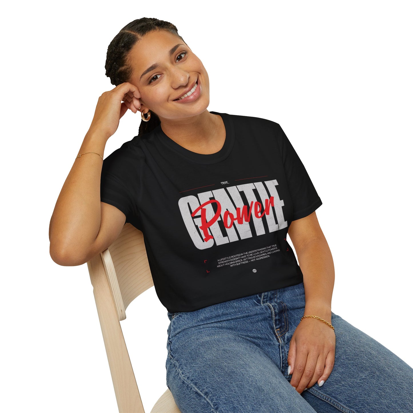 Woman wearing a black t-shirt with 'Gentle Power' text, sitting on a chair.